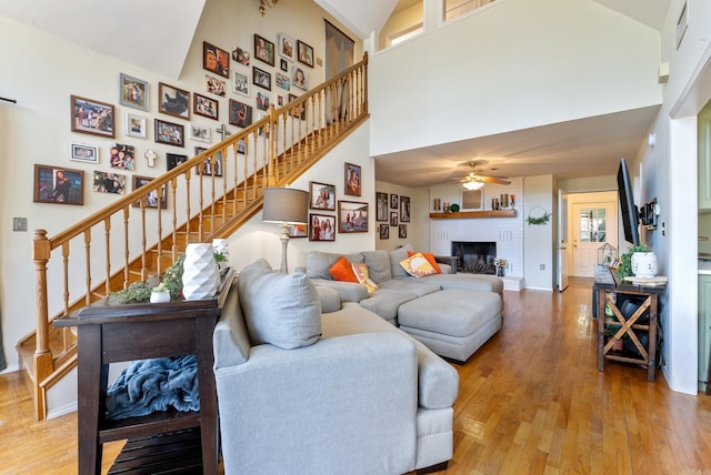8 Allen Pt, Perryville, AR 72126 - living room with stairway, a fireplace, a high ceiling, wood finished floors, and ceiling fan
