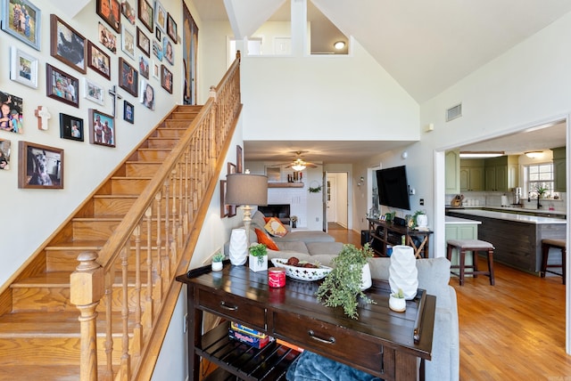 8 Allen Pt, Perryville, AR 72126 - living area with light wood-style flooring, visible vents, a brick fireplace, ceiling fan, and stairway