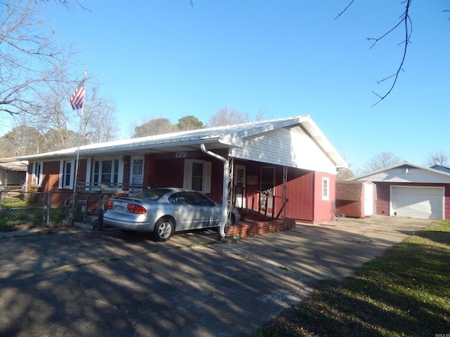 ranch-style house with an outdoor structure, an attached carport, driveway, and fence