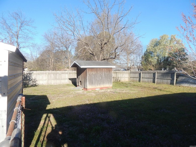 view of yard with a fenced backyard, an outbuilding, and a storage shed