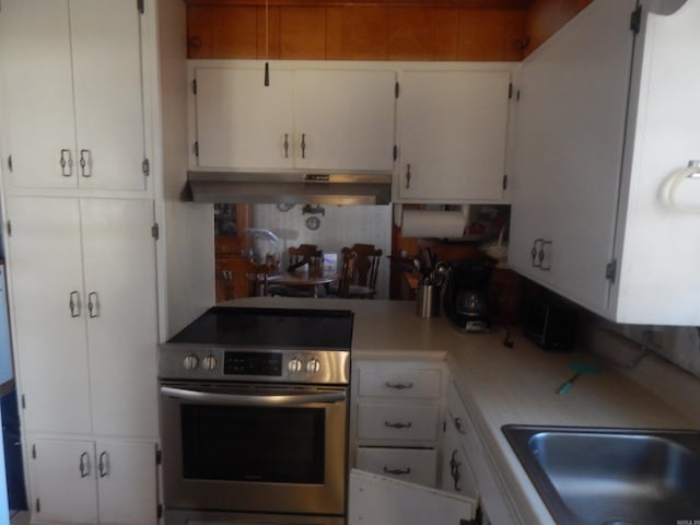 kitchen featuring white cabinetry, light countertops, a sink, and stainless steel electric stove