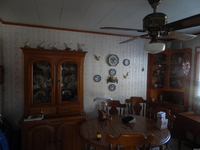 dining room with wallpapered walls, ornamental molding, and ceiling fan