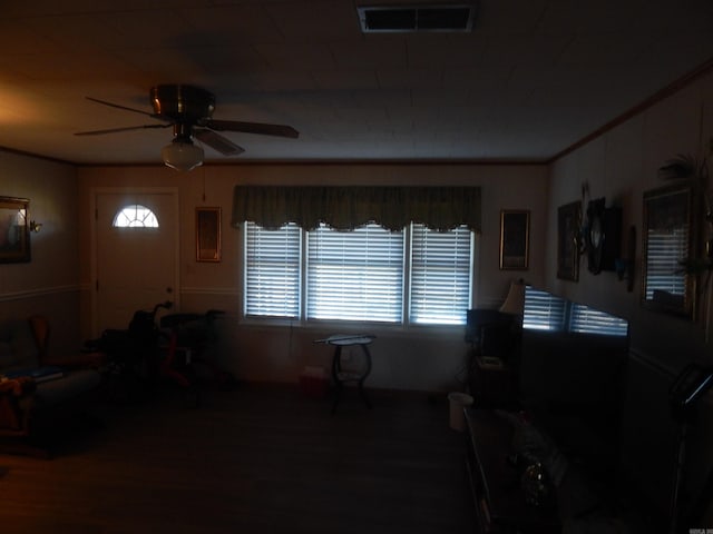 interior space featuring crown molding, visible vents, and a ceiling fan