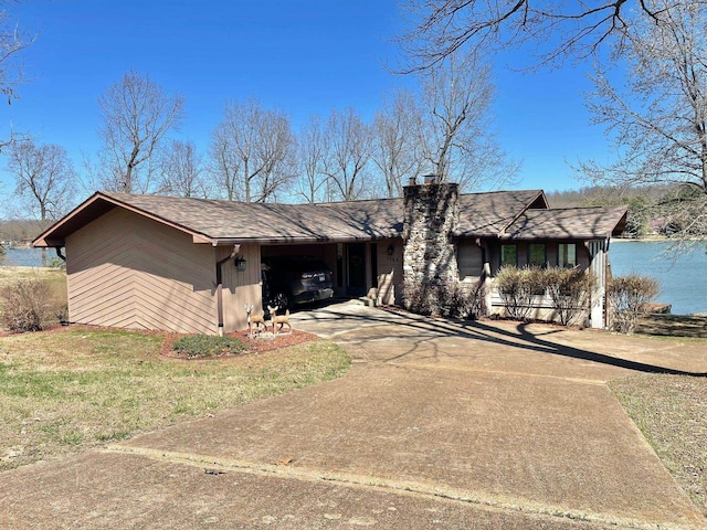 1104 Pearl Dr, Horseshoe Bend, AR 72512 - view of front of home featuring a water view, a chimney, an attached carport, driveway, and a shingled roof