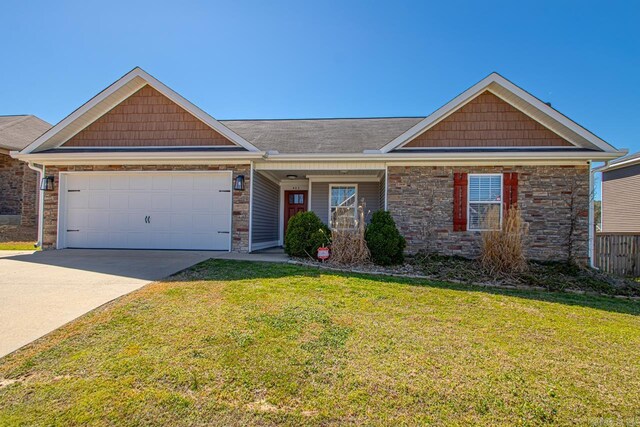 view of front of home with driveway, an attached garage, stone siding, and a front lawn