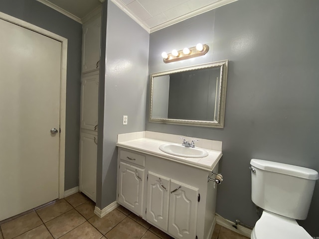 half bathroom with vanity, toilet, ornamental molding, baseboards, and tile patterned floors