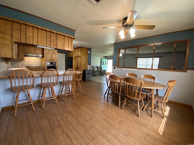 dining room featuring baseboards, wood finished floors, and a ceiling fan