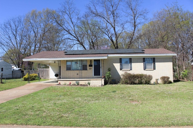view of front of property with fence, an attached carport, brick siding, a front lawn, and driveway