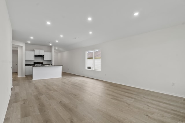 1233 Santa Fe Trl, Bauxite, AR 72011 - unfurnished living room with baseboards, light wood-type flooring, a sink, and recessed lighting