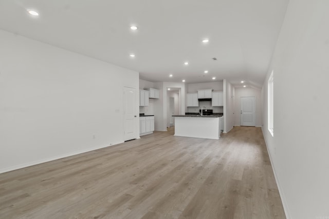 1233 Santa Fe Trl, Bauxite, AR 72011 - unfurnished living room featuring recessed lighting, baseboards, light wood finished floors, and a sink
