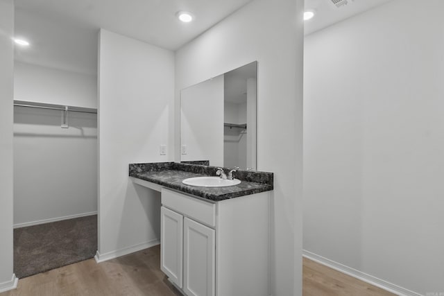 1233 Santa Fe Trl, Bauxite, AR 72011 - bathroom featuring vanity, wood finished floors, a spacious closet, and baseboards