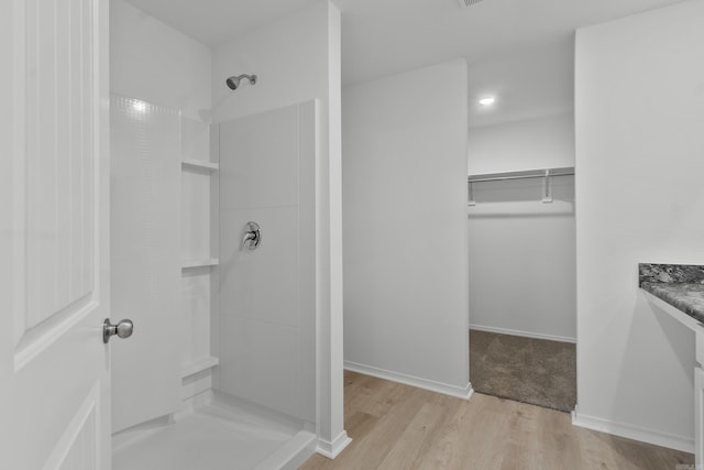 1233 Santa Fe Trl, Bauxite, AR 72011 - bathroom with a shower, wood finished floors, vanity, a walk in closet, and baseboards
