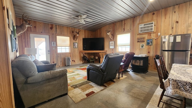44 Duncan Ln, Story, AR 71970 - living room featuring a wall mounted AC, wooden walls, concrete floors, a ceiling fan, and radiator