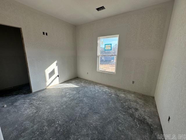empty room featuring unfinished concrete flooring and visible vents