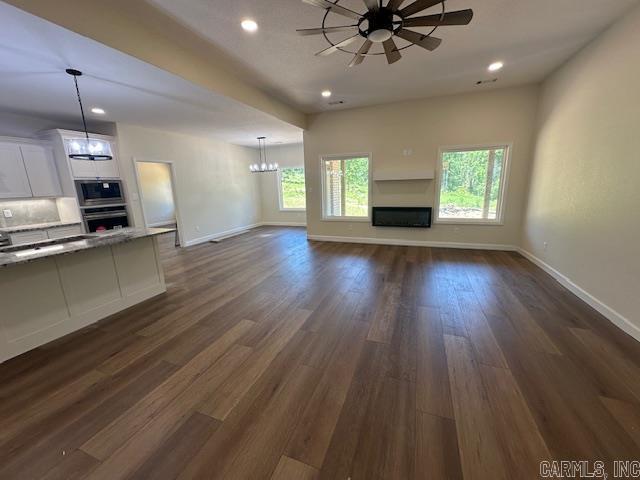 1000 Duke Dr, Bauxite, AR 72011 - unfurnished living room featuring a fireplace, baseboards, a ceiling fan, dark wood finished floors, and recessed lighting