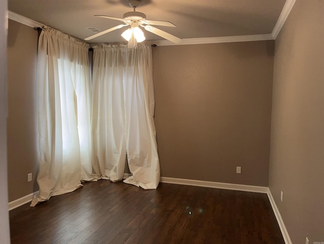 empty room with crown molding, dark wood-style flooring, ceiling fan, and baseboards