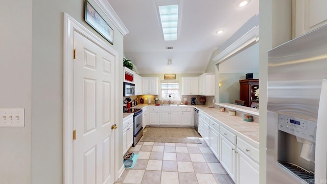 kitchen with white cabinetry, tile counters, backsplash, visible vents, and appliances with stainless steel finishes