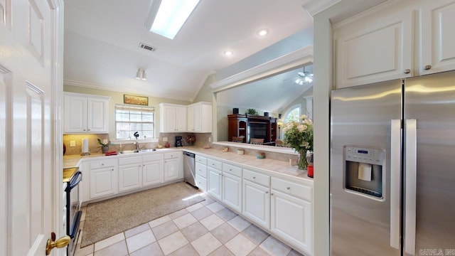 kitchen featuring backsplash, a sink, lofted ceiling, stainless steel appliances, and ceiling fan