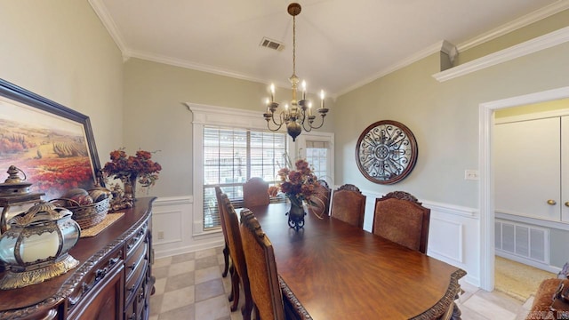 dining space featuring a wainscoted wall, visible vents, a notable chandelier, and ornamental molding