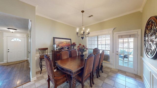 dining area with ornamental molding, a notable chandelier, baseboards, and visible vents