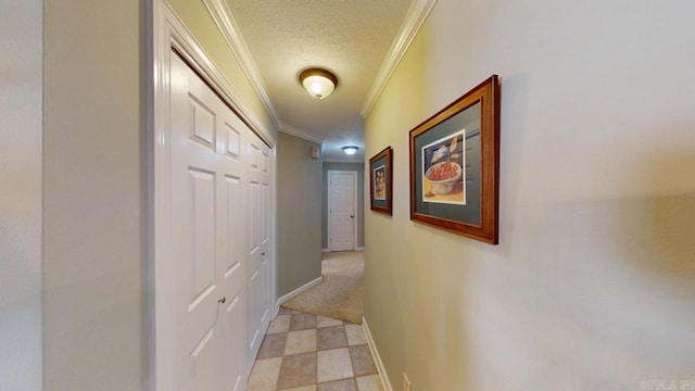 hall featuring baseboards, a textured ceiling, and crown molding