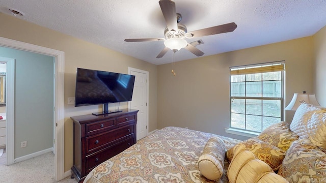 carpeted bedroom featuring baseboards, ceiling fan, and a textured ceiling