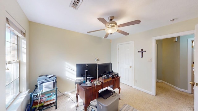 office space featuring light carpet, baseboards, visible vents, and ceiling fan