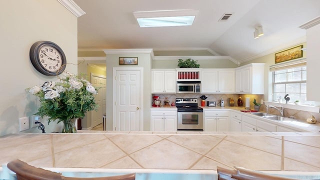 kitchen with stainless steel appliances, ornamental molding, backsplash, a sink, and visible vents