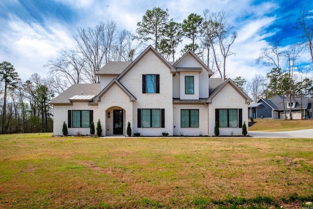 modern inspired farmhouse with a front lawn and board and batten siding