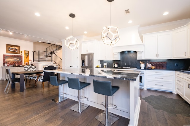 18 Ensbury Pl, Little Rock, AR 72223 - kitchen featuring dark wood-style flooring, visible vents, custom exhaust hood, appliances with stainless steel finishes, and white cabinetry