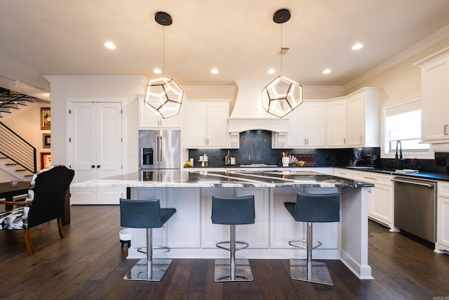 18 Ensbury Pl, Little Rock, AR 72223 - kitchen with backsplash, appliances with stainless steel finishes, a center island, custom range hood, and dark wood-style flooring