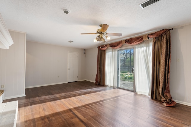 spare room with a textured ceiling, ceiling fan, visible vents, and hardwood / wood-style flooring