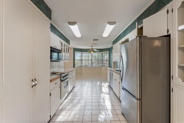 kitchen featuring light countertops, a ceiling fan, appliances with stainless steel finishes, white cabinetry, and light tile patterned floors