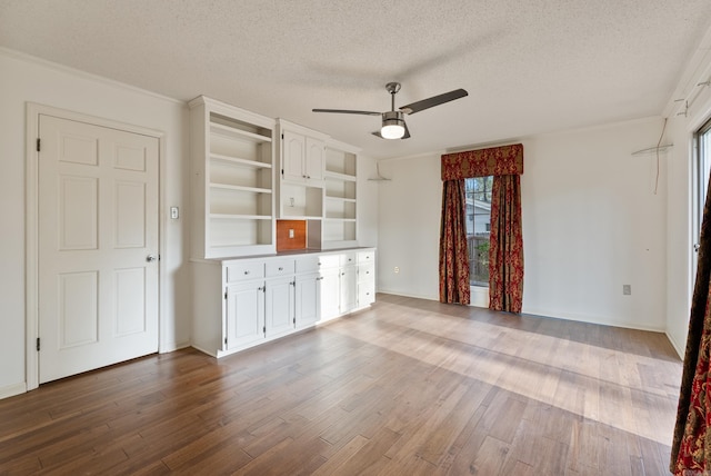 unfurnished living room with wood finished floors, a textured ceiling, and ceiling fan
