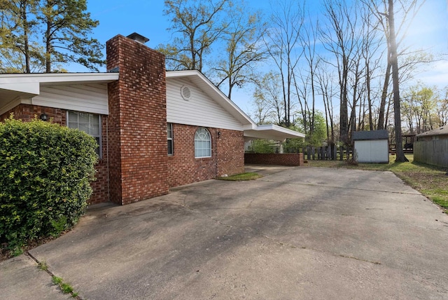 view of property exterior with a storage shed, brick siding, an outbuilding, and a chimney