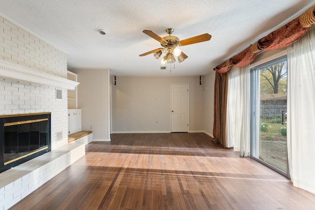 unfurnished living room featuring a fireplace, a textured ceiling, wood-type flooring, baseboards, and ceiling fan