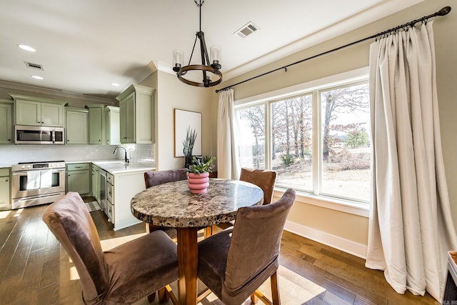 dining area with dark wood-type flooring, baseboards, a chandelier, and visible vents