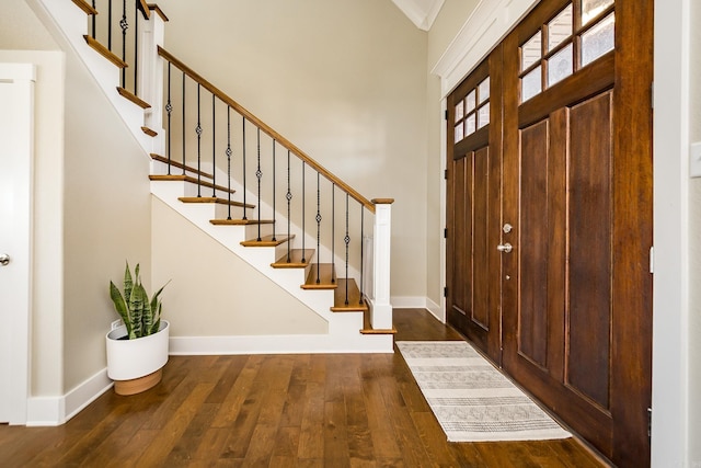 foyer with baseboards, stairs, and wood-type flooring