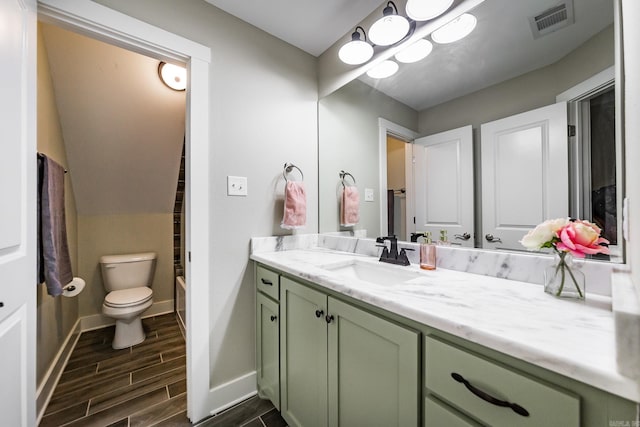 bathroom with vanity, wood finish floors, toilet, baseboards, and visible vents