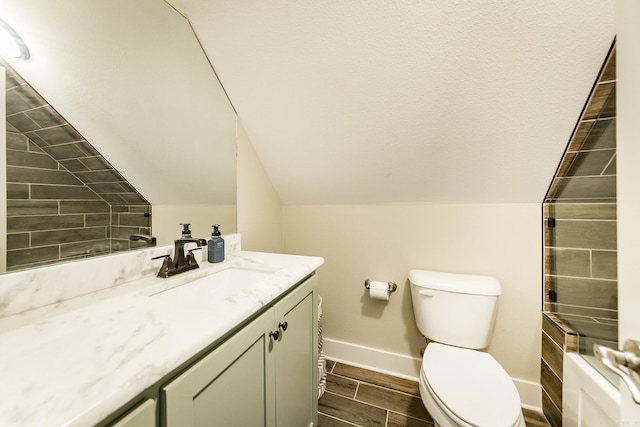 bathroom with vanity, lofted ceiling, toilet, baseboards, and wood tiled floor