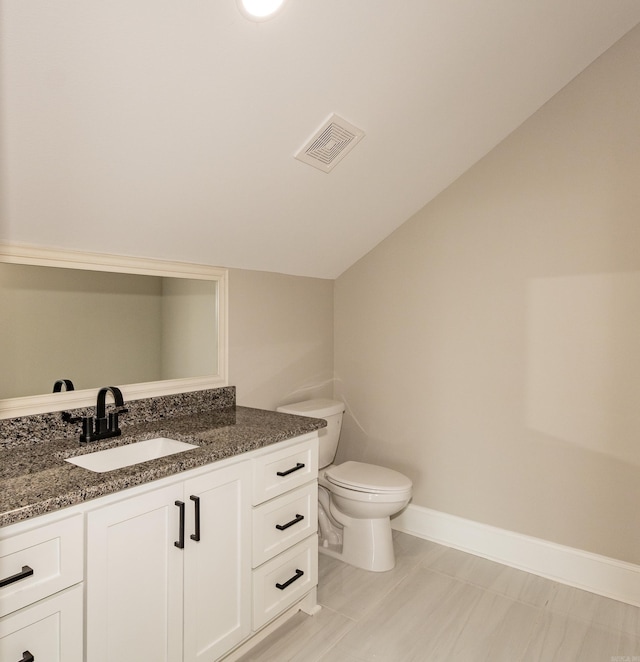 bathroom featuring toilet, vanity, baseboards, visible vents, and lofted ceiling