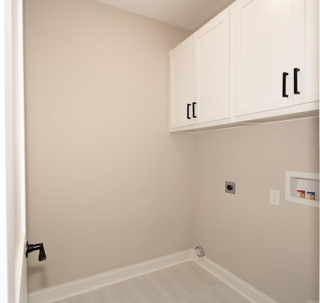 laundry area with electric dryer hookup, cabinet space, hookup for a washing machine, and baseboards