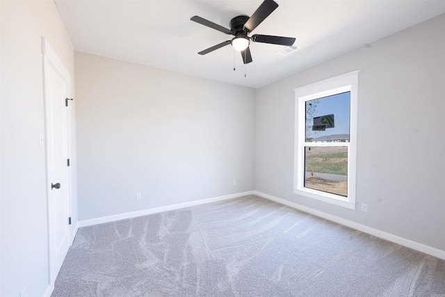 carpeted empty room featuring visible vents, baseboards, and ceiling fan