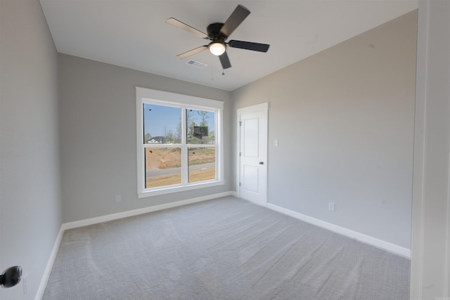 spare room featuring visible vents, baseboards, a ceiling fan, and carpet flooring