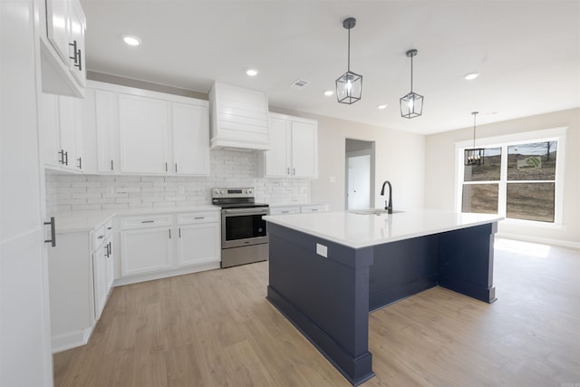 kitchen featuring custom exhaust hood, a sink, light wood-style floors, stainless steel electric range, and decorative backsplash