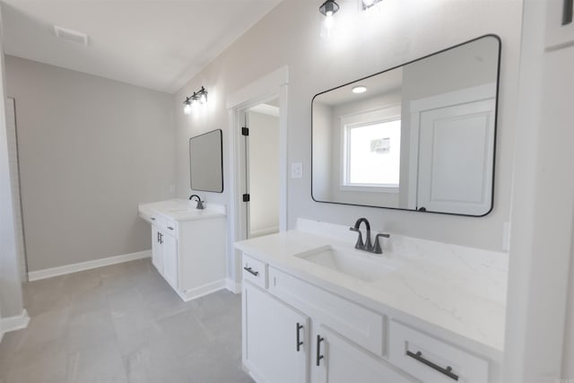 bathroom with two vanities, visible vents, baseboards, and a sink