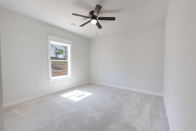 unfurnished room featuring baseboards, visible vents, light colored carpet, and a ceiling fan