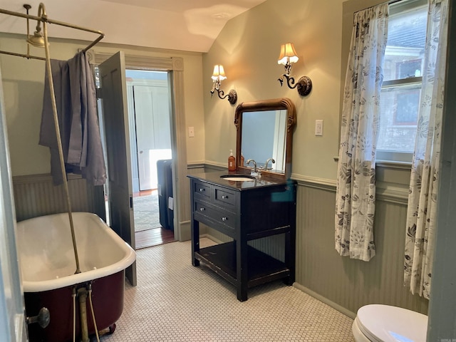 2107 Broadway St, Little Rock, AR 72116 - full bath featuring vaulted ceiling, toilet, vanity, wainscoting, and a freestanding tub