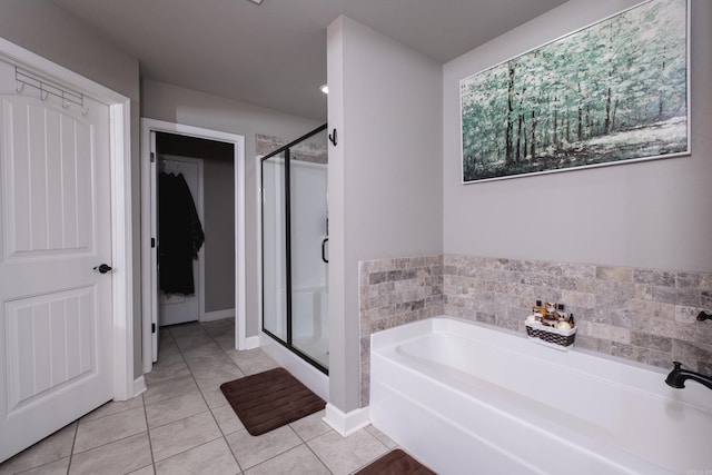 full bath featuring tile patterned flooring, a stall shower, baseboards, and a garden tub