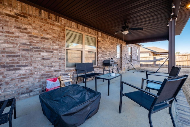 view of patio featuring area for grilling, fence, and a ceiling fan